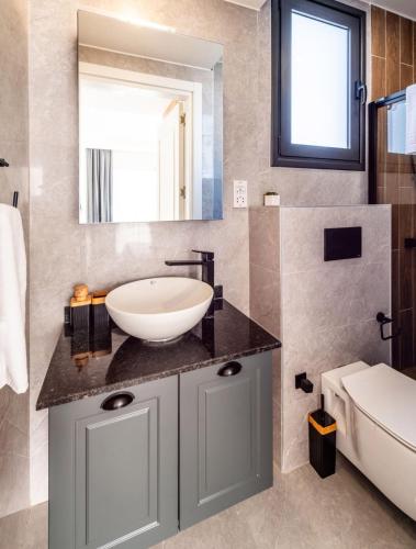 a bathroom with a sink and a mirror at Royal Villas in Kérynia