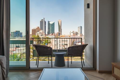 a balcony with two chairs and a view of a city at Casa Cibeles by Lumina in Mexico City
