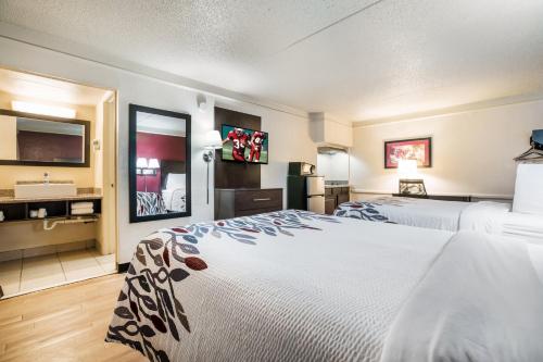 a hotel room with two beds and a refrigerator at Red Roof Inn Dallas - Richardson in Dallas