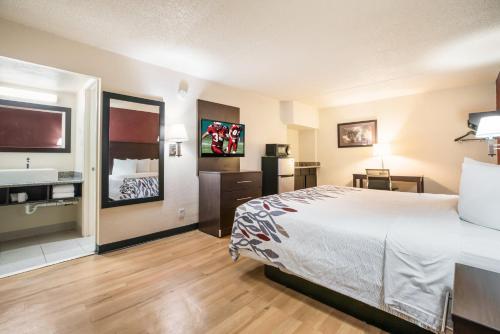 a hotel room with a bed and a sink at Red Roof Inn North Dallas - Park Central in Dallas