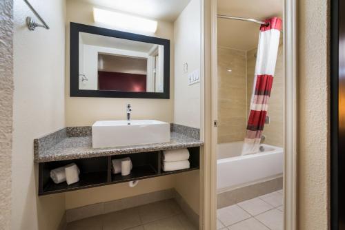 a bathroom with a sink and a tub at Red Roof Inn Dallas - Richardson in Dallas