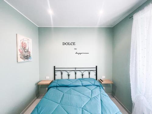 1 dormitorio con 1 cama azul y un cartel en la pared en Dolce Apartments Albano, en Albano Laziale