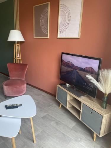un salon avec une télévision à écran plat sur une armoire dans l'établissement CHARMANT APPARTEMENT AVEC GRANDE CAPACITÉ D’ACCUEIL, à Saint-Jacques-de-la-Lande