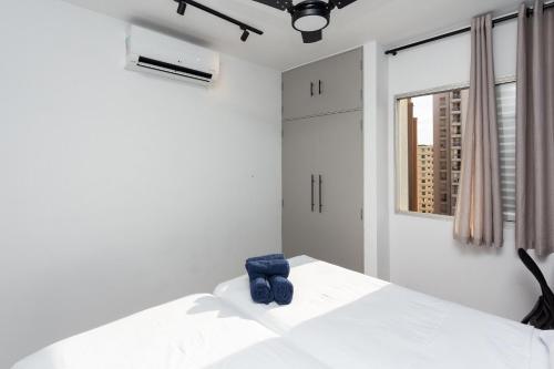 a bedroom with a white bed with blue objects on it at Apto 1 quarto, Centro, Cambuí, Guanabara, 1 vaga garagem, prox. a mercado, academia, hospital in Campinas