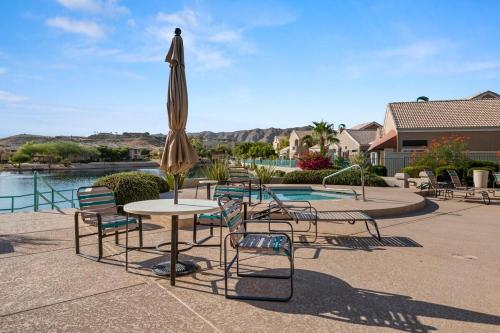 einen Tisch und Stühle mit einem Sonnenschirm und einem Pool in der Unterkunft Agave Cowboy in Phoenix