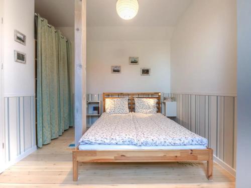 a bedroom with a bed with a wooden frame at Domek A 151 Malinowy- Kaszubska Ostoja in Barkocin