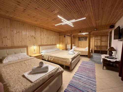 a bedroom with two beds and a wooden ceiling at Mani Guest House in Gjirokastër