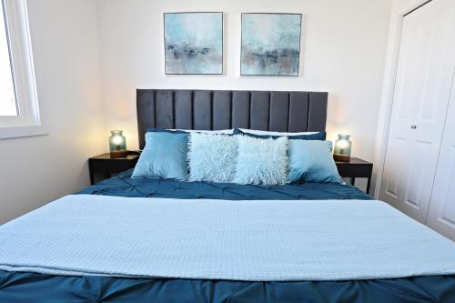 a bedroom with a blue bed with blue pillows at BoHo Retreat with King Beds, Golf, Disney+, Near WEM in Edmonton