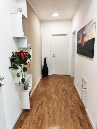 a hallway with white walls and a hard wood floor at Bastia Home Appartamento in Bastia Umbra