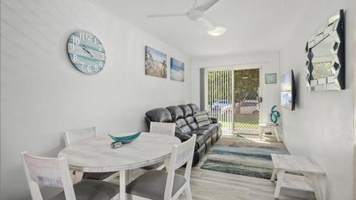 a living room with a table and a couch at Sand and Sea 1 - Opposite Sawtell's Main Beach & Steps to Cafes, Restaurants & Boutiques! in Sawtell
