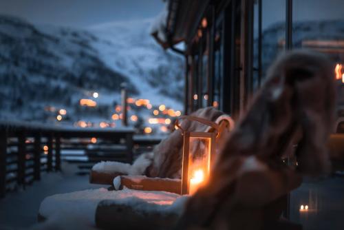 a lit candle sitting on a table with lights at Unique Romantic Cabin with Mountain View at Strandafjellet, Mivo X in Stranda
