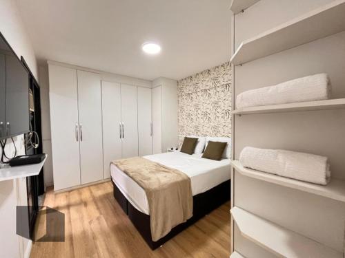a small bedroom with a bed and white cabinets at Excelente Apartamento no Leblon 02 quadras da praia em prédio com piscina, sauna e academia in Rio de Janeiro