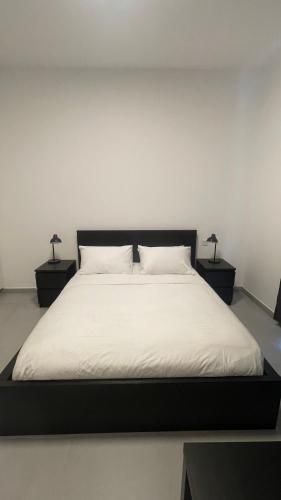 1 dormitorio con 1 cama con 2 lámparas en 2 mesas en Al jada / Reef 4, en Sharjah