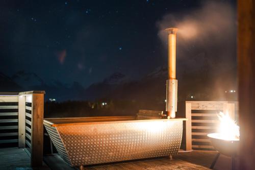 a bath tub sitting on a deck with a factory at Unique Romantic Cabin with Mountain View at Strandafjellet, Mivo X in Stranda