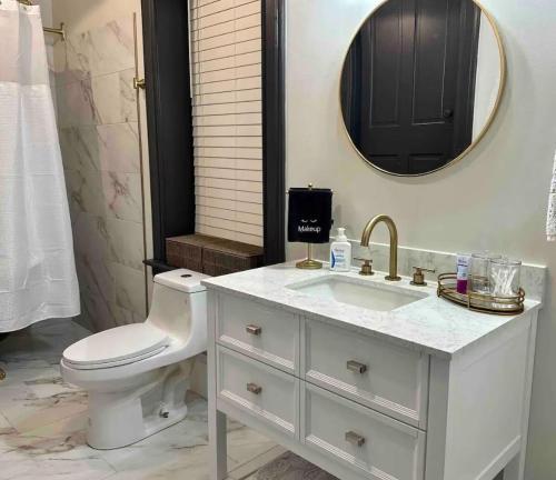 a bathroom with a sink and a toilet and a mirror at The Mercantile on the Katy Trail in Hermann