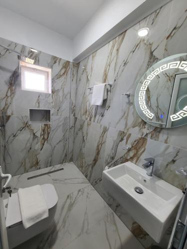 La salle de bains est pourvue d'un lavabo et d'un miroir. dans l'établissement Vila Koal, à Ksamil