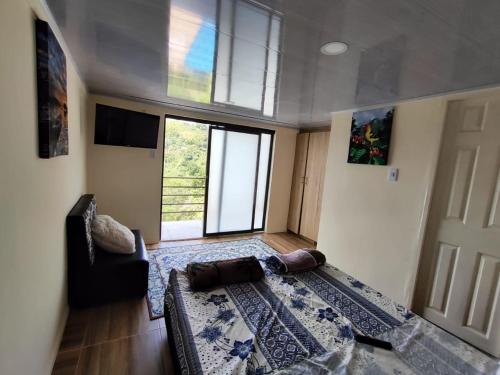 a living room with a bed and a window at Ecohotel Java in Manizales