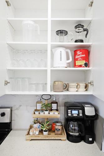 a kitchen with white cabinets and a coffee maker at BoHo Retreat with King Beds, Golf, Disney+, Near WEM in Edmonton