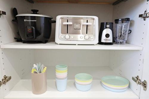 a kitchen shelf with a toaster and other kitchen items at BoHo Retreat with King Beds, Golf, Disney+, Near WEM in Edmonton