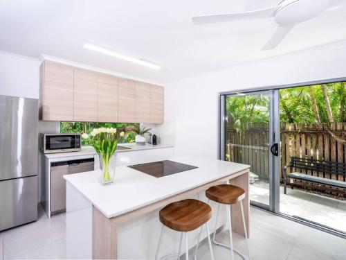 a kitchen with a counter with two stools at Serene 2BR Beachfront Getaway on the Esplanade in Clifton Beach