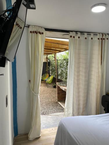 a room with a bed and a window with a curtain at Habitación de descanso con aire acondicionado in Villavicencio