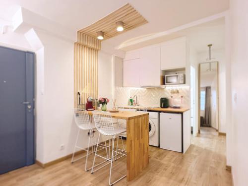 une cuisine avec une table et des chaises dans une pièce dans l'établissement Paris Marais center cozy flat besides Notre Dame, à Paris