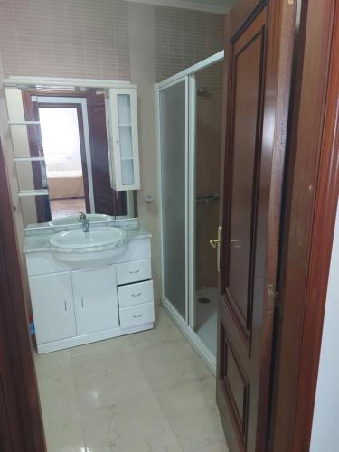 uma casa de banho com um lavatório, um chuveiro e um espelho. em Casa Fraga em Foz
