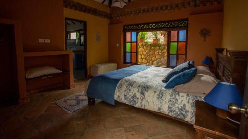 a bedroom with a bed with stained glass windows at Casas La Primavera in Villa de Leyva