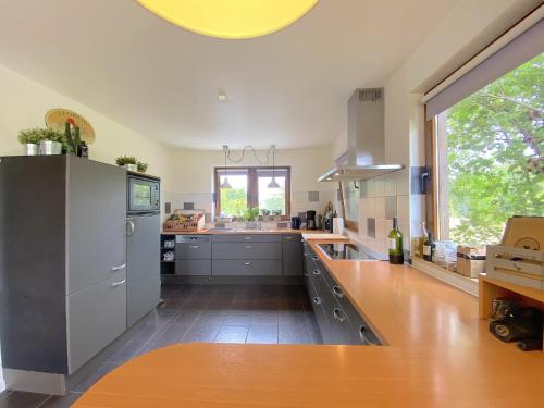 a kitchen with stainless steel appliances and a large window at Vakantiehuis Wilogne in Dinez