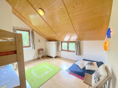 a room with a bed and a wooden ceiling at Vakantiehuis Wilogne in Dinez
