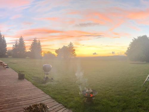a bbq grill in a field at sunset at Vakantiehuis Wilogne in Dinez