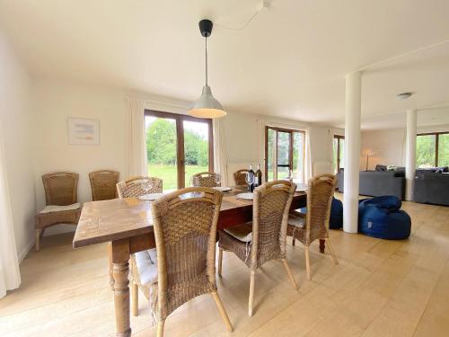 a dining room with a wooden table and chairs at Vakantiehuis Wilogne in Dinez