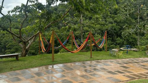 a group of colored hammocks in a park at Sítio Balango: Seu refúgio em Domingos Martins. Chalés para casais e casa para grupo de pessoas in Domingos Martins