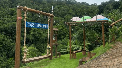 a swing with umbrellas and a sign that reads constitutional limbo at Sítio Balango: Seu refúgio em Domingos Martins. Chalés para casais e casa para grupo de pessoas in Domingos Martins