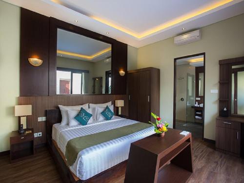 a bedroom with a large bed and a table at Buana Bali Villas & Spa in Jimbaran