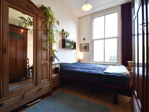 een slaapkamer met een bed en een groot raam bij De Kleine Regentes in Den Haag
