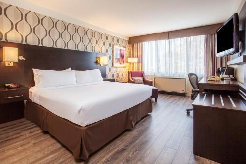 a hotel room with a large bed and a television at Holiday Inn Toronto International Airport, an IHG Hotel in Toronto