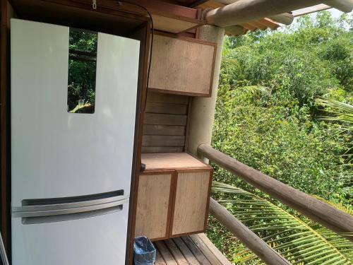 a white refrigerator sitting on a deck with a porch at Apartamento mezanino Villas do pratagy in Maceió