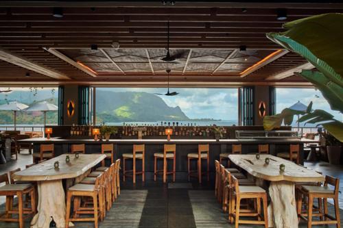 a restaurant with tables and chairs and a large window at 1 Hotel Hanalei Bay in Princeville