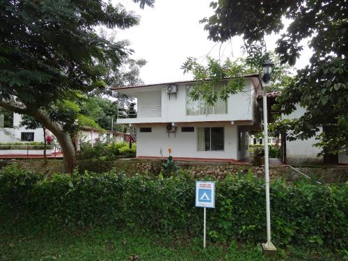 a white house with a sign in front of it at CENTRO VACACIONAL & HOTEL CAMPESTRE LAGO CENTER in Aguazul