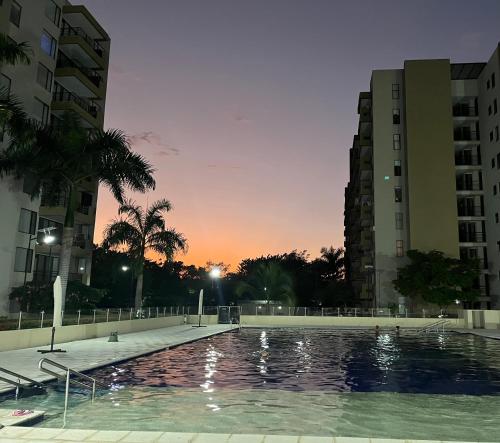 a swimming pool in the middle of two buildings at Confortable Apto en Hacienda Peñalisa in Ricaurte