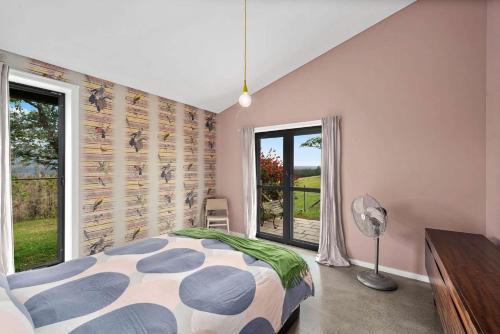 a bedroom with a bed and a large window at Moosewood House, Kangaroo Valley in Kangaroo Valley