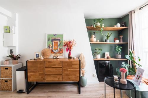 Cette chambre dispose d'une commode en bois et d'étagères avec des plantes. dans l'établissement Appartement Feydeau - Welkeys, à Paris