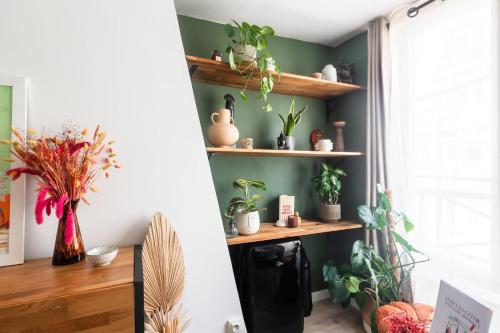 Cette chambre est dotée de murs verts et d'étagères avec des plantes. dans l'établissement Appartement Feydeau - Welkeys, à Paris