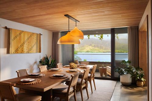 a dining room with a large wooden table and chairs at 1 Hotel Hanalei Bay in Princeville