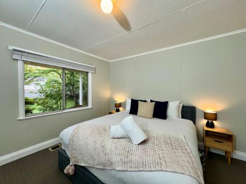 una camera con un grande letto e una finestra di Maple Grove a Katoomba