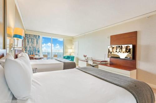 a hotel room with two beds and a flat screen tv at 21st Floor Luxury Suite at Trump Int Resort in Miami Beach