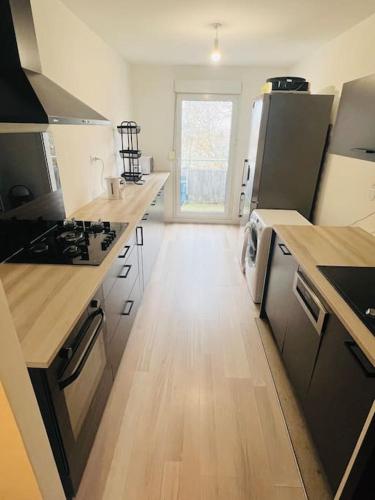 une grande cuisine avec un plancher et des comptoirs en bois dans l'établissement Apparemment F3 Nancy, à Nancy