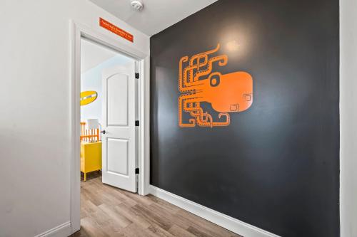 an orange sign on a black wall in a hallway at Beach House Steps away from the Boardwalk and Beach with Ocean Views in Seaside Heights! in Seaside Heights