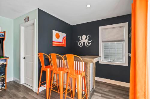 a dining room with orange chairs around a table at Beach House Steps away from the Boardwalk and Beach with Ocean Views in Seaside Heights! in Seaside Heights